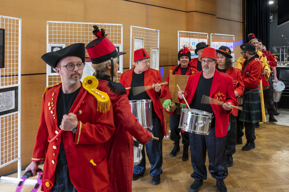 La Fanfare défile en costume rouge et noir à l'occasion des 30 ans du CARPA